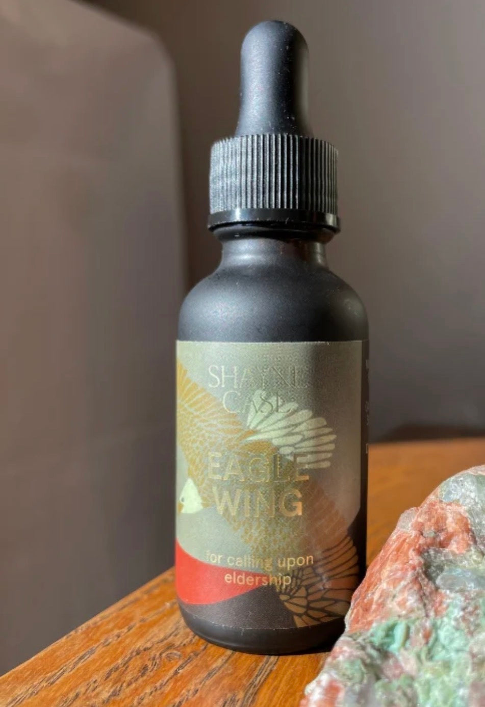 Bottle with dropper labeled 'Eagle's Wing' on a wooden surface with a blurred background