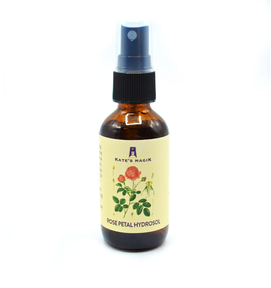Amber glass bottle of rose petal hydrosol with a spray top labeled 'Kate's Magic' on a white background